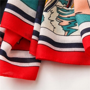 Detail of soft cotton-linen scarf with red border and colorful horse carriage pattern