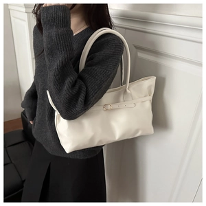 Détail du sac cabas blanc crème minimaliste avec boucle métal sur pull en maille