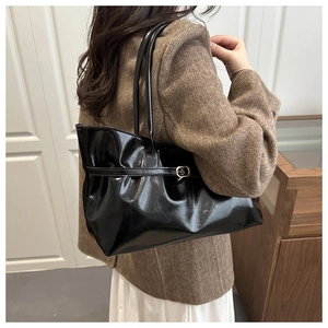 Détail du sac cabas vintage noir brillant avec boucle en métal et texture plissée