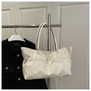Détail du grand sac cabas crème avec sangles fines et boucle dorée en métal