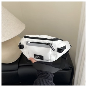 Détail d'un sac banane blanc avec fermeture réfléchissante et sangle noire ajustable