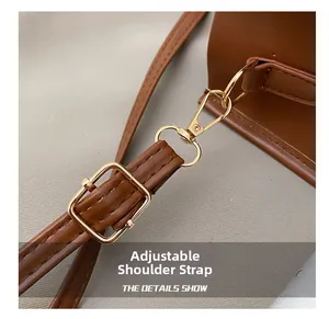 Détail de la bandoulière réglable en cuir marron avec boucle et fermoir en métal doré