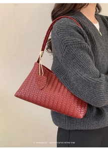 Détail du sac à main en cuir tressé rouge avec texture en damier et bandoulière robuste