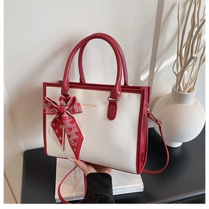 Détail du sac à main rouge et blanc à motif serpent avec foulard en soie à cœurs