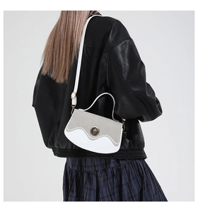 Vista posteriore di una modella con borsa a tracolla bicolore e chiusura in metallo