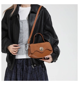 Dettaglio borsa a tracolla marrone vintage con patchwork in pelle scamosciata e fibbia