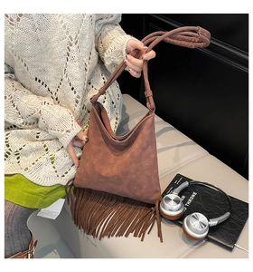 Détail du sac hobo en daim marron avec de longues franges et un design minimaliste