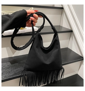 Détail du sac hobo noir avec de longues franges et une finition à texture mate