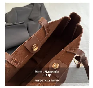 Detail of brown tote bag with suede lining and golden magnetic snap closures