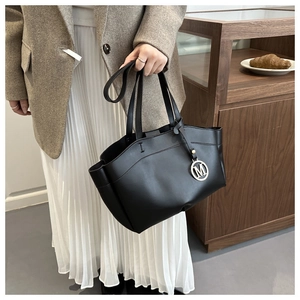 Chic black matte leather tote bag detail with a silver round letter M pendant charm