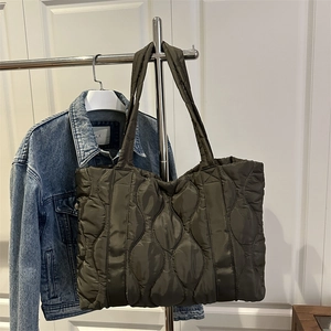 Quilted olive green tote bag in puffer material with spacious capacity and long handles