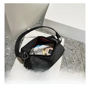 Vue détaillée du sac cylindre en paillettes noires avec doublure bordeaux spacieuse