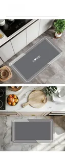 Close-up of grey absorbent kitchen mat with white HOME lettering and non-slip texture