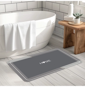 Detail of grey diatom mud absorbent mat with HOME logo in modern bathroom setting