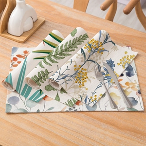 Floral cotton linen placemat set on light wood table with cutlery and home decor