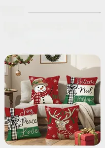 Détail de housses de coussin de Noël avec renne et bonhomme de neige sur un canapé