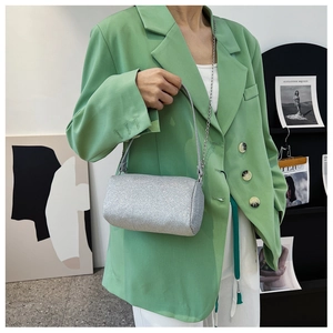 Vue détaillée d'un sac cylindrique à paillettes argentées avec chaîne en métal et poignée