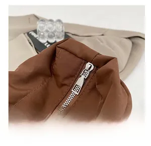 Macro shot of smooth silver metal zipper on dark brown padded shoulder tote bag
