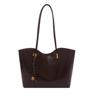 Deep burgundy glossy leather tote bag with long straps and gold bell charm detail