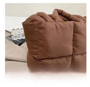 Detail view of brown quilted puffer tote bag showing soft padded texture and stitching