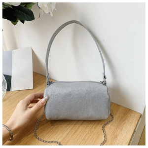 Détail du sac cylindrique argenté pailleté avec chaîne métallique et fermeture éclair