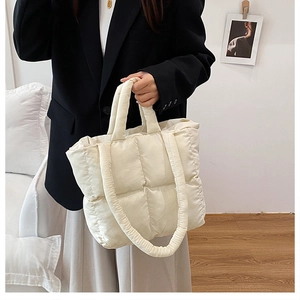 Detailed shot of cream quilted puffer tote bag with soft padded texture and dual straps