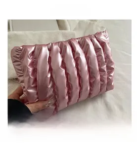 Detail showing pink quilted cloud makeup bag with soft pleated texture and satin finish