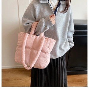 Detailed macro view of pink quilted tote bag with soft padded texture and top handle