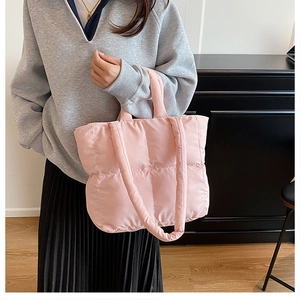 Close-up of pink quilted puffer shoulder bag with soft padded texture and dual straps