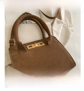 Close-up of vintage brown matte tote with gold metal lock and fine suede texture