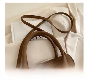Detailed macro view of retro brown suede handles and premium golden hardware on a handbag