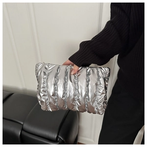 Detail of silver quilted makeup bag with metallic finish and soft padded texture