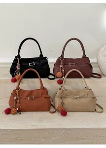 Four colors of vintage suede tote bags displayed on stone steps with decorative charms