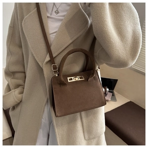Detail of vintage matte leather crossbody bag with gold hardware and top handle strap