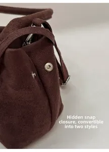 Detail of dark brown faux suede tote showing silver snap closure and dual shape options