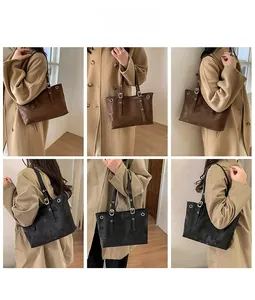 Detail of rivet studded shoulder straps on brown and black leather tote bags