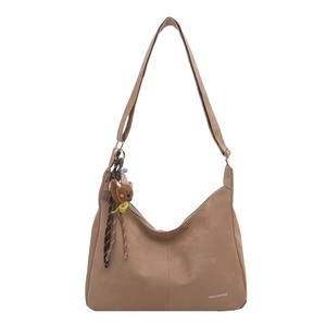 Brown half-moon tote bag with bear charm and adjustable shoulder strap on white background