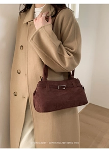 Detail of retro burgundy suede tote bag with minimalist silver metal buckle and soft texture