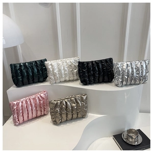 Faltige Kosmetiktaschen in Metallic-Farben auf einem modernen, weißen, minimalistischen Stand