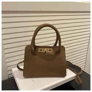 Detail of vintage dark brown matte leather handbag with gold twist lock and top handle