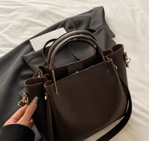 Gros plan détaillé sur le cuir grainé marron et la poignée d'un sac seau élégant