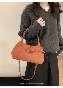 Detail of retro faux suede tote bag featuring adjustable strap and buckle accents