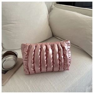 Dettaglio della borsa da trucco rosa metallizzato con trama trapuntata e pieghe