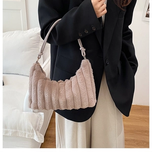 Detail of plush faux fur shoulder bag with vertical quilting and knotted handle design