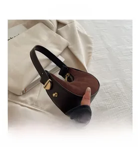 Macro detail of crescent bag showing brown leather texture and gold hardware zipper