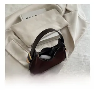 Internal view of the brown suede crescent bag showing lipstick and earphone capacity