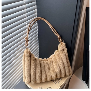 Detailed macro view of camel faux fur texture and pleated vertical ribs on the shoulder bag