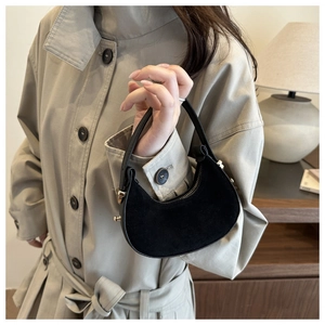Detail of black crescent bag showing contrast between suede texture and smooth leather