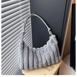 Macro detail of plush faux fur texture and rope strap on gray winter shoulder bag