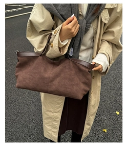 Dettaglio macro della borsa tote in pelle scamosciata marrone opaco con finiture in pelle